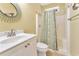 Bathroom featuring a white vanity, toilet, shower with curtain, and a round mirror at 2808 N Ocean Blvd., North Myrtle Beach, SC 29582