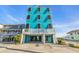 Beautiful teal beach house featuring black shutters and white trim in a bright and sunny setting at 2808 N Ocean Blvd., North Myrtle Beach, SC 29582