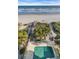 Private pool near a wooden walkway to the beach with surrounding palm trees and vegetation at 2808 N Ocean Blvd., North Myrtle Beach, SC 29582
