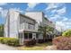 A multi-story condo building featuring gray siding, white balconies, and lush landscaping at 3700 Golf Colony Lane # 21 B, Little River, SC 29566