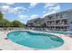 Beautiful outdoor pool with plenty of seating and well-maintained landscaping and building exterior at 3700 Golf Colony Lane # 21 B, Little River, SC 29566