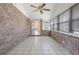 The sunroom features brick walls, tile floors, a ceiling fan, and sliding glass doors leading to the home's interior at 4300 Cross Cut Trail, Myrtle Beach, SC 29579