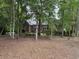 Backyard view of a brick home surrounded by mature trees at 4535 Carriage Run Circle, Murrells Inlet, SC 29576