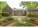 Brick home featuring a backyard patio with seating and manicured garden at 4535 Carriage Run Circle, Murrells Inlet, SC 29576