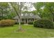 Traditional brick home with a columned front porch and manicured lawn surrounded by mature trees at 4535 Carriage Run Circle, Murrells Inlet, SC 29576