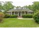Traditional brick home with a columned front porch and manicured lawn offers Southern charm at 4535 Carriage Run Circle, Murrells Inlet, SC 29576