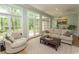 Sun-drenched sun room featuring tile flooring, ample seating, and views of the landscaped yard at 4535 Carriage Run Circle, Murrells Inlet, SC 29576