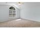Bright, carpeted bedroom with vaulted ceiling and arched window offering ample natural light and a serene atmosphere at 4591 Hidden Creek Ln., Myrtle Beach, SC 29579