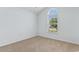 A light-filled bedroom with neutral carpet and a large window offering views of the neighborhood at 4591 Hidden Creek Ln., Myrtle Beach, SC 29579
