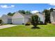 Charming single-story home with a white exterior, two-car garage, and a beautifully landscaped front yard at 4591 Hidden Creek Ln., Myrtle Beach, SC 29579