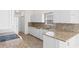 Modern kitchen with granite countertops, a tiled backsplash, white cabinets, and wood-look flooring at 4591 Hidden Creek Ln., Myrtle Beach, SC 29579