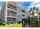 Exterior view of the Magnolia Place condo building showing well-maintained facade, private balconies, and mature landscaping at 4741 Wild Iris Dr. # 303, Myrtle Beach, SC 29577