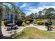 Outdoor picnic area with tables, charcoal grill, and lush landscaping, perfect for relaxation and entertainment at 4741 Wild Iris Dr. # 303, Myrtle Beach, SC 29577