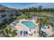 Aerial view of pool with plenty of lounge chairs and tropical landscaping, surrounded by a golf course at 4741 Wild Iris Dr. # 303, Myrtle Beach, SC 29577