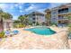 Inviting outdoor pool area with lounge chairs, lush landscaping, and beautiful condo building views at Magnolia Place at 4741 Wild Iris Dr. # 303, Myrtle Beach, SC 29577