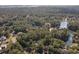 Aerial view showcasing the property's secluded location surrounded by dense trees and bordering a tranquil pond at 487 Lantana Circle, Georgetown, SC 29440