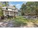 Expansive backyard featuring a screened porch, outdoor kitchen, stone fire pit, and gazebo seating area at 487 Lantana Circle, Georgetown, SC 29440