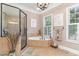 Bright bathroom with a corner tub, glass-enclosed shower, and a window that provides lots of natural light at 487 Lantana Circle, Georgetown, SC 29440