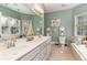 Well-lit bathroom with a dual sink vanity, a large mirror, and a bathtub with tile surround at 487 Lantana Circle, Georgetown, SC 29440
