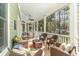 Relaxing screened porch with wicker furniture, ceiling fan, and wooded views at 487 Lantana Circle, Georgetown, SC 29440