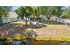 Aerial view of backyard featuring a fire pit, screened porch, and lush greenery for outdoor enjoyment at 5036 Billy K Trail, Myrtle Beach, SC 29579