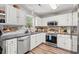 Well-lit kitchen with stainless steel appliances, gray counters and wood-look flooring at 5036 Billy K Trail, Myrtle Beach, SC 29579