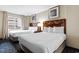 Bright bedroom features two beds, framed art, side table with lamp, and large window at 5200 N Ocean Blvd. # 833, Myrtle Beach, SC 29577