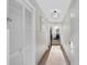 Long hallway featuring neutral tile floors, white walls, storage and an ornate light fixture at 5200 N Ocean Blvd. # 833, Myrtle Beach, SC 29577
