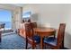 Comfortable living area features a TV, blue patterned carpet, and a sliding door to the balcony at 5200 N Ocean Blvd. # 833, Myrtle Beach, SC 29577