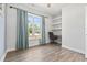 Office room featuring hardwood floors, built-in shelves, and a large window bringing in natural light at 5876 Cremona Dr., Myrtle Beach, SC 29577