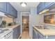 Compact kitchen featuring blue cabinets, white appliances, and sufficient counter space at 6001-5610 S Kings Hwy., Myrtle Beach, SC 29575