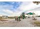 Community playground on a sandy surface, featuring slides, benches, and a covered area at 6001-5610 S Kings Hwy., Myrtle Beach, SC 29575