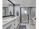Elegant bathroom with dual sinks, quartz countertops, a glass shower, and modern fixtures at 603 S Ocean Blvd. # 1101, North Myrtle Beach, SC 29582
