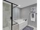 Contemporary bathroom with a corner shower, luxurious bathtub, and grey tile at 603 S Ocean Blvd. # 1101, North Myrtle Beach, SC 29582