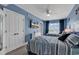 Charming blue bedroom with two beds, a ceiling fan, a TV, and natural light from the large window at 603 S Ocean Blvd. # 1101, North Myrtle Beach, SC 29582