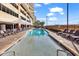 Outdoor pool with lounge chairs around the perimeter, set next to a high-rise building and beach at 603 S Ocean Blvd. # 1101, North Myrtle Beach, SC 29582