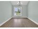 The dining room has hardwood flooring, a modern chandelier, and a bright window at 604 Highway 747, Loris, SC 29569