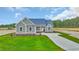 Charming craftsman-style home with blue siding, landscaped yard, and a paved driveway at 604 Highway 747, Loris, SC 29569