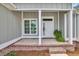 Inviting front porch with brick accents, white columns, and a well-lit entrance at 604 Highway 747, Loris, SC 29569
