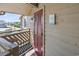 Balcony entrance with wood railing, red door, and sign that says 'live in the sunshine' at 609 Hillside Dr. S # C-16, North Myrtle Beach, SC 29582