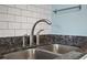 Close-up of a modern kitchen sink with granite countertops and a subway tile backsplash at 609 Hillside Dr. S # C-16, North Myrtle Beach, SC 29582