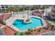 Inviting community pool surrounded by ample seating, palm trees, and a charming pool house at 609 Hillside Dr. S # C-16, North Myrtle Beach, SC 29582