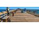 Picturesque view of a wooden pier with benches, a unique Adirondack chair, and ocean views at 617 Hibiscus Ave. # 617, Myrtle Beach, SC 29577