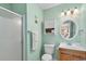 Light and airy bathroom with a shower, wooden vanity, medicine cabinet, and mint green walls at 6302 N Ocean Blvd. # G-3, North Myrtle Beach, SC 29582