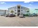 Three-story condo complex with ample parking, palm trees and outdoor stairwells at 6302 N Ocean Blvd. # G-3, North Myrtle Beach, SC 29582