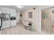 Well-lit kitchen featuring white appliances and cabinets, a mosaic tile backsplash, and adjacent dining area at 6302 N Ocean Blvd. # G-3, North Myrtle Beach, SC 29582