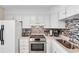 Well-maintained kitchen with stainless steel appliances, white cabinetry, and stylish tile backsplash at 6302 N Ocean Blvd. # G-3, North Myrtle Beach, SC 29582