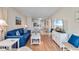 Bright living room featuring a blue sofa, nautical decor, and a view into the kitchen and dining area at 6302 N Ocean Blvd. # G-3, North Myrtle Beach, SC 29582