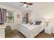 Cozy bedroom with carpet, two windows with lilac curtains, and a white bed with decorative pillows at 6734 Blue Heron Blvd. # 104, Myrtle Beach, SC 29588