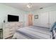 Bright bedroom featuring a ceiling fan, dresser with TV, and a comfortable striped bedspread at 6734 Blue Heron Blvd. # 104, Myrtle Beach, SC 29588